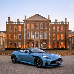 a blue sports car parked in front of a large building