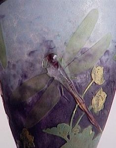 a close up of a vase with flowers and leaves painted on the outside of it