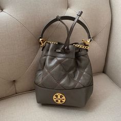 Brand New With Tags New Tory Burch Willa Mini Bucket Bag Color: Volcanic Stone / 066 Product Dimensions 6 X 3 X 7 Inches Luxury Gray Shoulder Bag, Formal Gray Bag With Detachable Strap, Gray Leather Evening Bag, Luxury Taupe Evening Bag, Designer Gray Shoulder Bag With Gold-tone Hardware, Luxury Gray Shoulder Bag With Dust Bag, Designer Gray Shoulder Bag, Gray Luxury Shoulder Bag For Evening, Designer Taupe Evening Bags