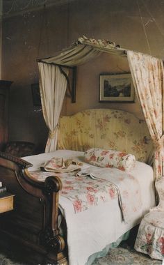 an old fashioned bedroom with floral bedspread and curtains