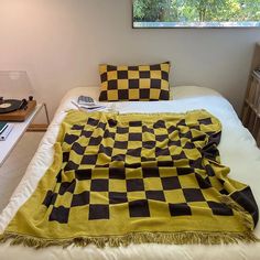 a yellow and black checkered blanket on a bed