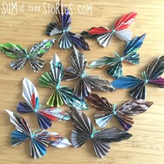 several different colored paper butterflies on a wooden surface with text overlay that says sum of four stories com