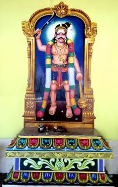 a statue of the hindu god maha in front of a yellow wall