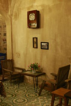 a living room with chairs and a clock on the wall