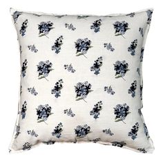 a white pillow with blue flowers on it