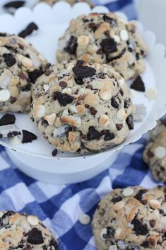 chocolate chip cookies with white and black chips on a blue checkered tablecloth, ready to be eaten