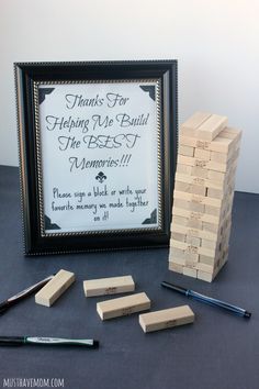 a wooden block tower sitting on top of a table next to a framed sign that says thanks for helping me build the best memories