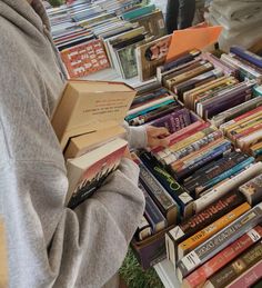 a person standing in front of a table filled with books