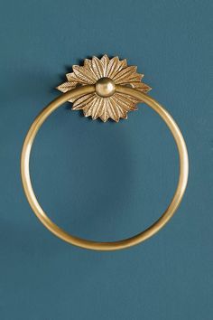 a close up of a gold ring on a blue surface with a flower design in the middle