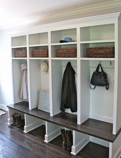 an entryway with white shelving and wooden flooring