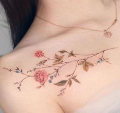 a woman's chest with flowers and leaves on the top part of her breast