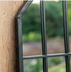 an open window on the side of a building with wood and metal bars in it