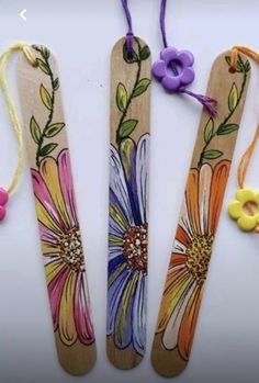 three wooden spoons decorated with flowers and beads