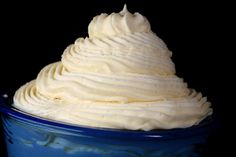 a blue bowl filled with whipped cream on top of a table