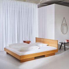 a bed sitting in the middle of a white room