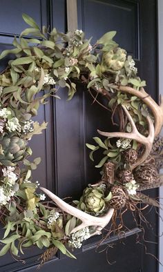 a wreath with flowers and antlers on the front door