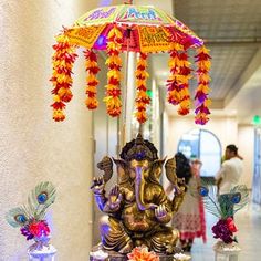 an elephant statue sitting on top of a table next to vases filled with flowers