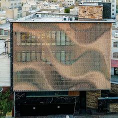 an old building is covered in mesh on top of a hill overlooking the city below