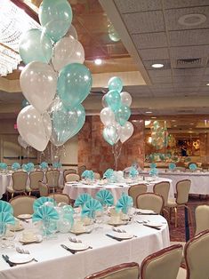 the table is set up for a party with blue and white balloons, silverware, and napkins