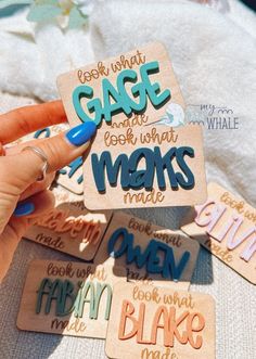 someone holding up some wooden magnets with words on them that read, cage what makes me