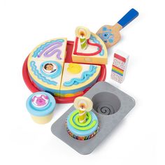 an assortment of toys including a cake, cupcake and cookie cutters on a white background