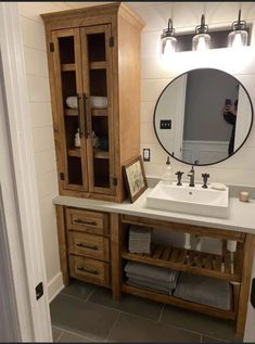 a bathroom with a sink, mirror and wooden cabinets