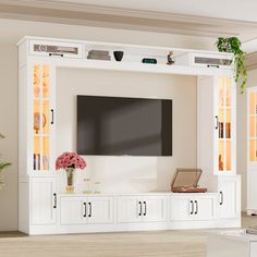 a living room with white furniture and a flat screen tv mounted to the side of it