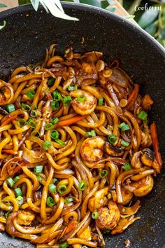 a wok filled with noodles and shrimp