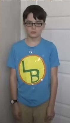 a young boy wearing a blue shirt with the letter b on it's chest