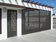 a black and white building with a large gate on the side of it's wall