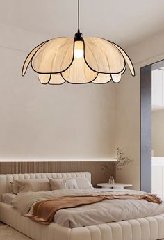 a large bed sitting under a light fixture in a living room next to a window