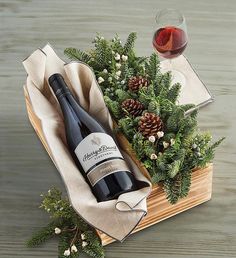 a bottle of wine sitting on top of a wooden table next to a glass of wine