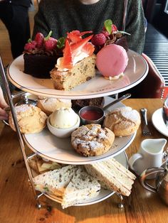 three tiered trays with desserts and pastries on them at a restaurant