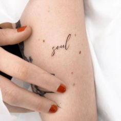 a woman's arm with the word soul tattooed on her left side ribcage