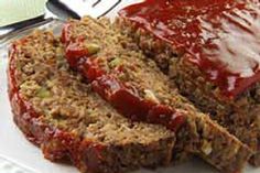 sliced meatloaf with ketchup on a white plate next to a fork