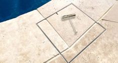 a pool with a tile floor next to it and a metal pole sticking out of the ground