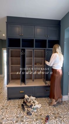 a woman standing in front of a cabinet with shoes on the floor