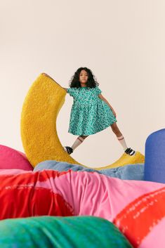 a woman standing on top of a pile of pillows