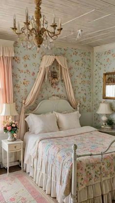 a white bed sitting in a bedroom next to a chandelier above a window