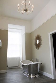 a bathroom with a tub and chandelier in it