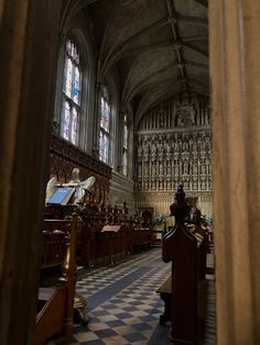 the inside of a church with pews and stained glass windows on both sides,