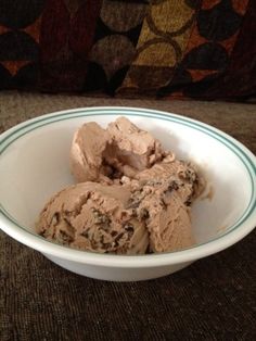 a bowl filled with ice cream sitting on top of a couch