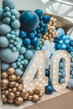 the number forty sign is surrounded by balloons and streamers in blue, gold and white