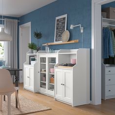 a living room with white furniture and wooden floors