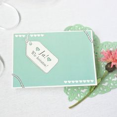 a pink flower sitting on top of a piece of paper