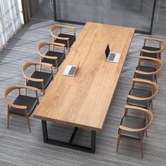 a conference table with chairs around it and a laptop on the desk in front of it