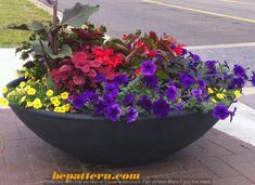 a large black planter filled with colorful flowers