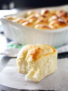 a piece of bread sitting on top of paper next to a casserole dish