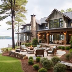 a large house sitting on top of a lush green field next to a body of water