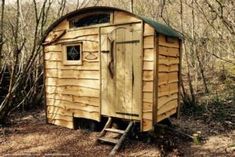 a small wooden outhouse in the woods